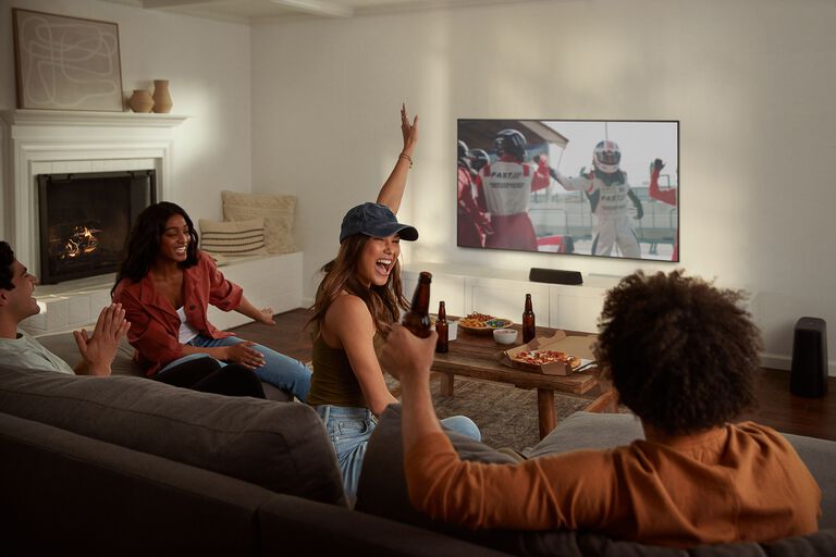 Woman excited watching sports with sound bar Woman excited watching sports with sound bar
